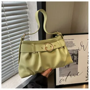 Dettaglio borsa a mano verde chiaro con pieghe, cinturino decorativo e fibbia dorata