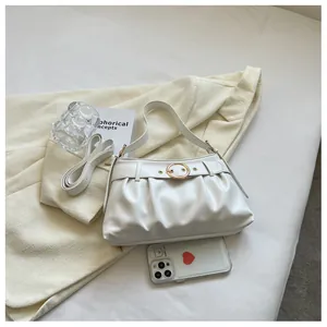 Dettaglio della borsa a pieghe bianca con fibbia a cerchio dorata e texture in ecopelle