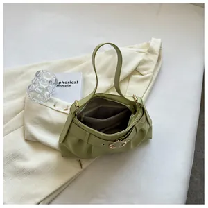 Dettaglio borsa a pieghe verde chiaro con fibbia decorativa e tasca interna a zip