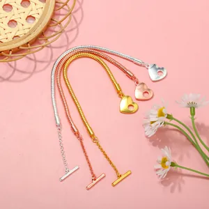 Dettaglio di bracciali a catena serpente in tre colori con ciondolo a cuore e chiusura OT