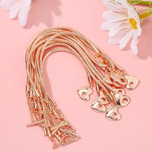 Dettaglio della catena a serpente in oro rosa con pendente a cuore e chiusura a T