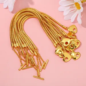 Dettaglio del bracciale a catena serpente dorata con ciondolo a cuore e chiusura a T