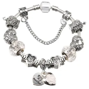 Detail of silver snake chain bracelet with MOM heart charms and pink enamel flower