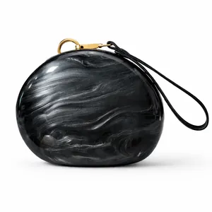 Detailed macro view of black and grey marble textured acrylic shell with gold metal clasp