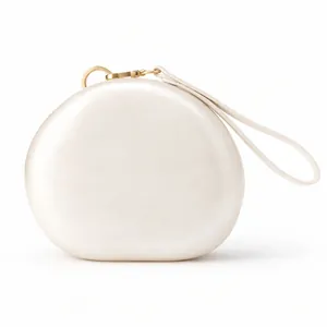 Close-up of minimalist pearl white acrylic evening clutch with gold circular buckle