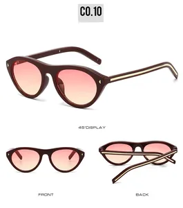 Cat eye sunglasses detail with burgundy frame, gradient lenses and gold rivets