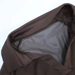 Détail du haut marron foncé à manches longues en mesh avec col pointu et décolleté V