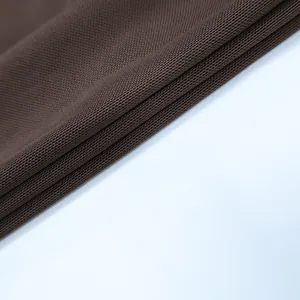 Gros plan sur le tissu marron foncé à texture alvéolée pour cet ensemble chemise