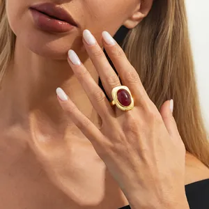 Retro gold-finish statement ring featuring a large oval red gemstone on female hand