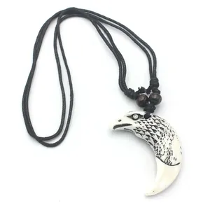 Détail macro du pendentif tête d'aigle en résine avec plumes et perles en bois