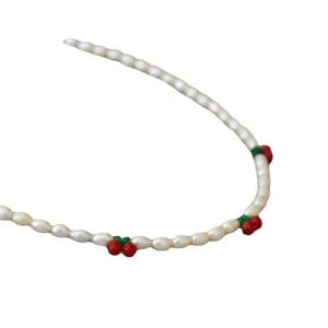 Collier en perles d'eau douce fait main avec pendentifs cerises rouges sur fond blanc