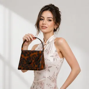 Detail of a pearl luster leopard print acrylic clutch bag with a tortoiseshell pattern finish