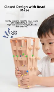 Close-up of child holding a sealed wooden maze toy with colorful beads and acrylic panel