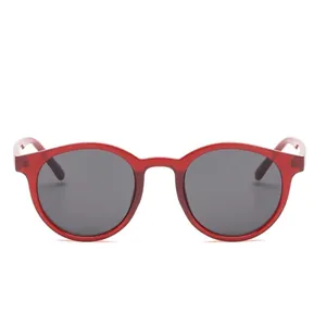 Occhiali da sole rotondi vintage con montatura rossa traslucida e lenti grigio scuro