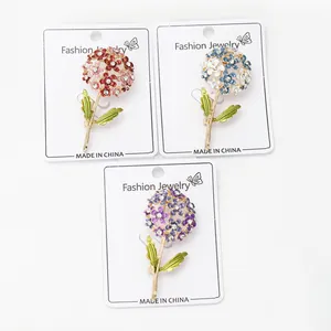 Detailed macro shot of floral crystal brooches in red, blue and purple alloy finishes