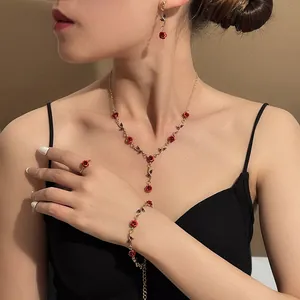 Detailed view of an elegant French vintage jewelry set featuring red roses worn by a model