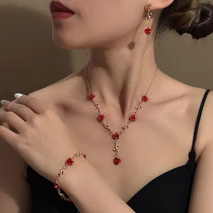 Close-up of vintage red rose jewelry set including necklace, bracelet and earrings