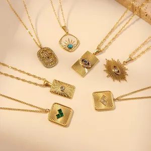 Détail de colliers bohèmes dorés avec pendentifs main de fatma et œil de protection