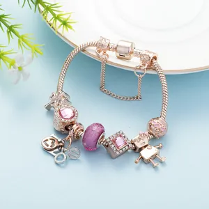 Nahaufnahme von Roségold Schlangenarmband mit rosa Anhängern und Roboter-Anhänger