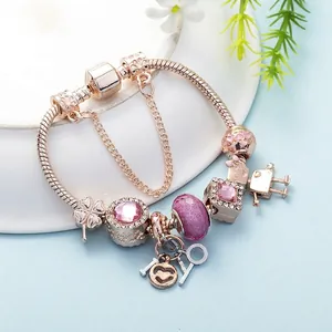 Detailansicht eines roségoldenen Charm-Armbands mit Herzanhänger und Kristallen