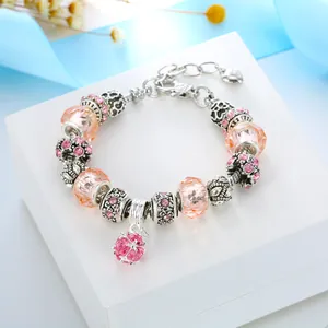 Close-up of pink crystal beads and rhinestone charms on a silver alloy bracelet