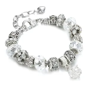 Macro detail of silver charm bracelet with faceted crystal beads and a crystal ball pendant