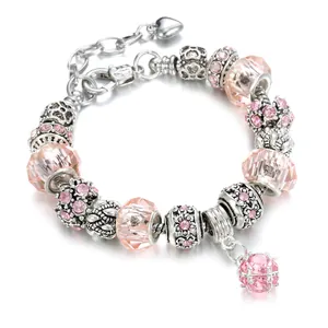 Detailed view of a pink beaded charm bracelet with crystal drops and heart pendant