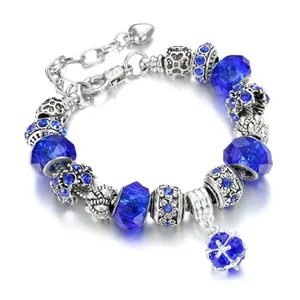 Fashion alloy charm bracelet with deep blue glass beads and heart pendant on white background