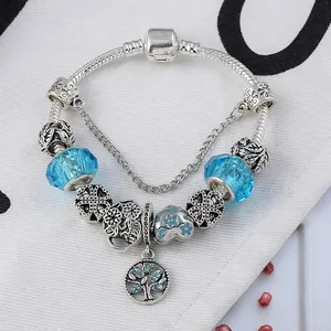 Détail du bracelet chaîne serpent en argent avec pendentif arbre de vie et perles bleues