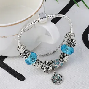 Détail macro de l'arbre de vie et perles de verre bleues sur bracelet maille serpent