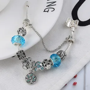 Détail du pendentif arbre de vie et perles de cristal bleu sur bracelet à maille serpent