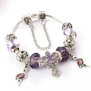 Detail of beaded bracelet featuring purple crystal beads and pink flamingo charms