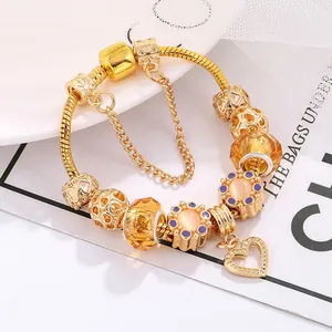 Detailed shot of golden snake chain bracelet with amber crystal beads and heart charm
