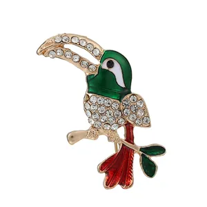 Golden toucan brooch with green enamel, sparkling rhinestones and red details