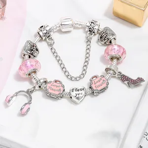 Rosa Reise-Charm-Armband mit Koffer und High Heels an einer silbernen Schlangenkette
