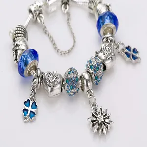 Silver charm bracelet with blue glass beads and four-leaf clover pendants on snake chain