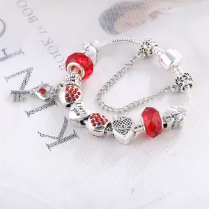 Silbernes Perlenarmband mit roten Perlen und I Love You Herzanhängern auf weißem Netz