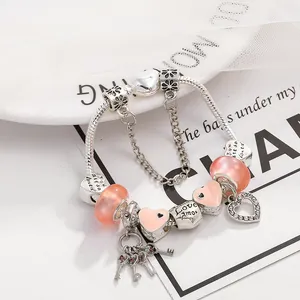 Romantisches Herz-Charm-Armband mit rosa Glasperlen und Love Amor Silberanhänger