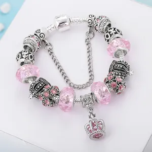 Detail showing pink faceted crystal beads and crown charms on a silver snake chain bracelet