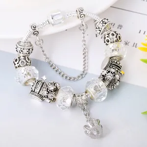 Close-up of crown pendant and sparkling crystal beads on silver snake chain bracelet