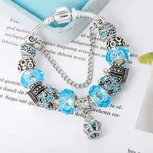Detailed shot of crown charm bracelet featuring light blue faceted crystal beads and silver snake chain