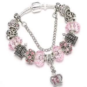 Elegant silver crown charm bracelet featuring pink faceted crystals and a safety chain