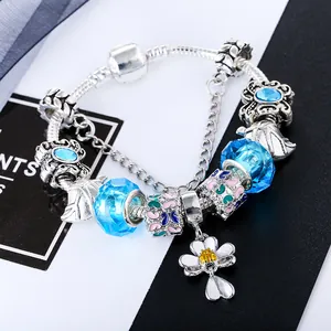 Detail van zilveren slangketting armband met blauwe kristallen en vlinderbedels