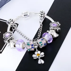 Macro-opname van zilveren bedelarmband met paarse glaskralen en klaverhanger