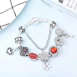 Pulsera de cuentas plateada con corazones de cristal rojo, margaritas y llave de amor
