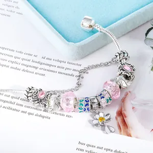 Macro-opname van vlinderhangers en roze glazen kralen op een zilveren slangenketting
