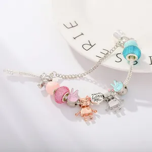 Macro view of silver snake chain charm bracelet with pink glass beads and cute robot charms