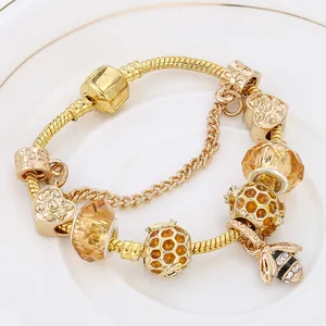 Bracelet à breloques doré avec pendentif abeille, cristaux ambrés et perles en nid d'abeille