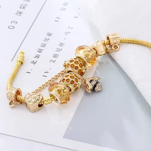 Bracelet charm abeille dorée avec cristaux jaunes et pendentif cœur sur chaîne serpent