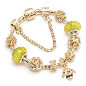 Gouden bijenarmband met gele facetkralen en strikaccenten aan een slangenketting